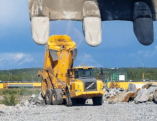 Keltainen kuorma-auto kippaamassa kiviä